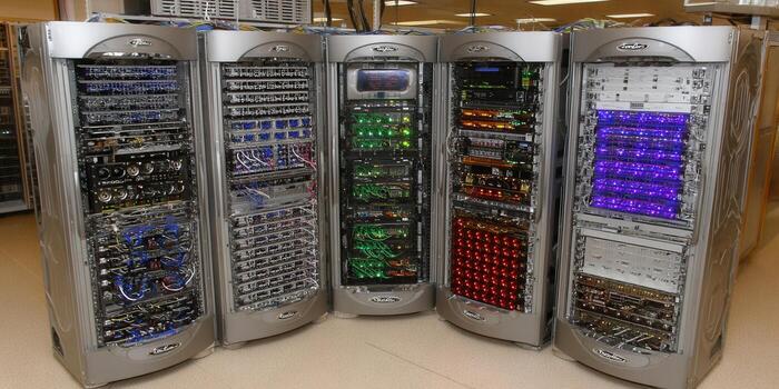 Five server racks are lined up, filled with intricate computing components and lights, showcasing network infrastructure. photo