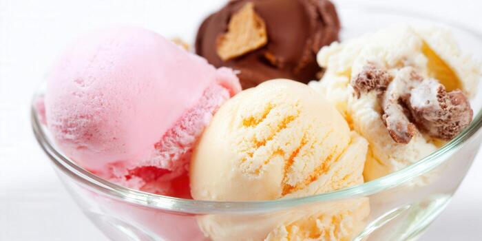 A delicious close-up of multiple scoops of colorful ice cream in a glass bowl. photo