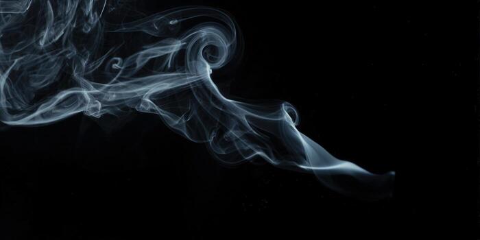 Graceful wisps of smoke dance across a black background, creating a mesmerizing abstract composition. photo