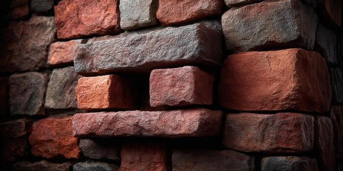 A weathered stone wall with red and brown bricks, creating a textured backdrop. photo