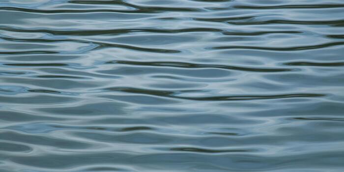 The image showcases the gentle, rhythmic patterns of rippling water, creating a captivating abstract scene. photo