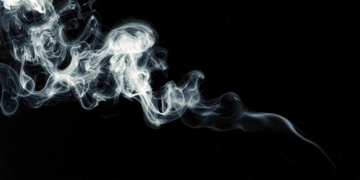 Elegant wisps of smoke dance against a deep black background, creating an ethereal and artistic visual. photo