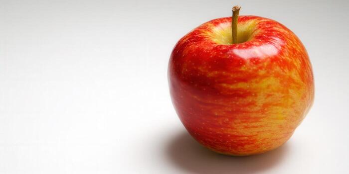 A close-up of a fresh, ripe red apple against a white backdrop. photo