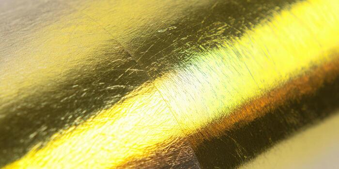 Intricate golden surface with a subtle, textured effect and reflective sheen, creating a luxurious background. photo