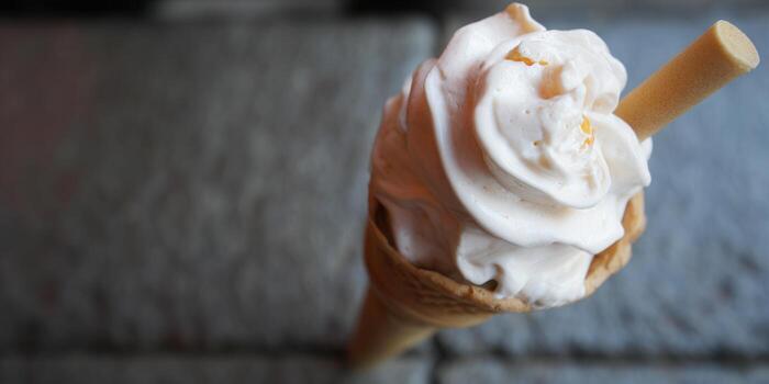 Close-up of a creamy vanilla ice cream cone with a wafer stick. photo