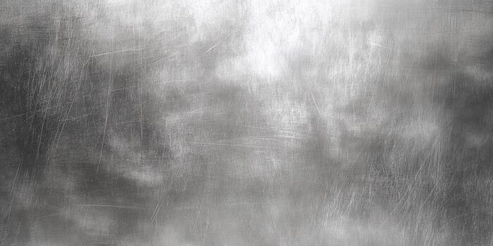 A close-up view of a brushed metallic surface with a textured gray background. photo