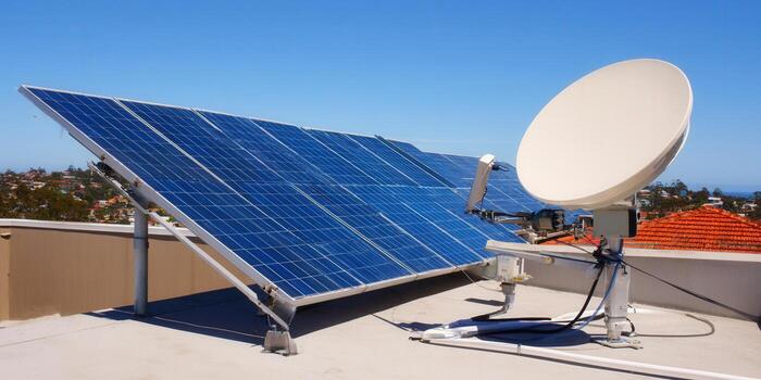 Solar panels and satellite dish on a roof, capturing sunlight for a greener future and efficient communication. photo