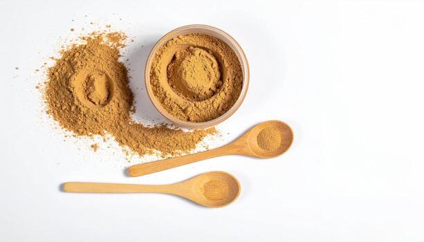 Light tan powder in a bowl and wooden spoons on a white background photo
