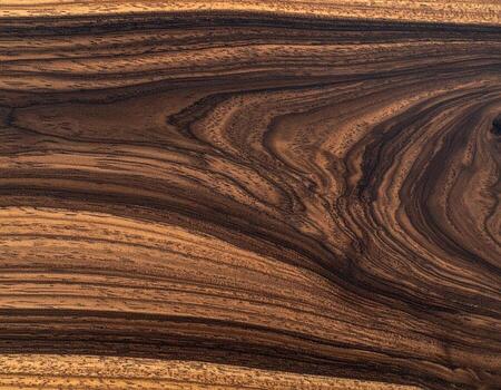 de cerca de rico, oscuro madera grano. un liso, horizontal superficie muestra intrincado, fluido patrones de oscuro marrón y ligero marrón madera foto
