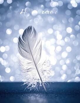 A single, delicate white feather rests on a dark surface, against a backdrop of soft, light-blue bokeh photo