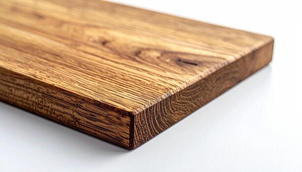 Close-up of a rectangular wooden cutting board. The wood grain is visible, displaying warm brown tones and darker streaks. A sharp edge of the board is highlighted photo