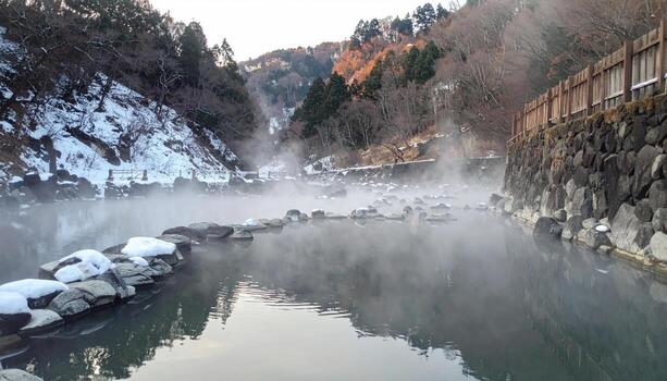 A misty hot spring nestled in a mountain valley, snow-capped peaks in the background photo