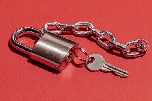A padlock and key on a red surface photo