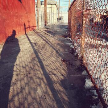 A man is standing in front of a fence photo