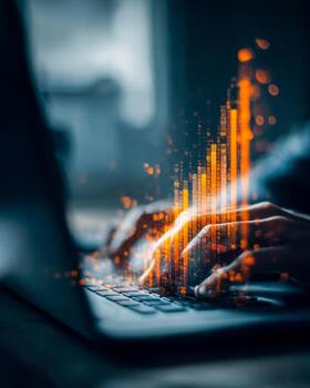 Person typing on a laptop with digital data and graphs overlay in a dark environment photo