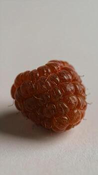 Macro shot of a perfectly ripe raspberry showing intricate textures and vibrant color detail photo