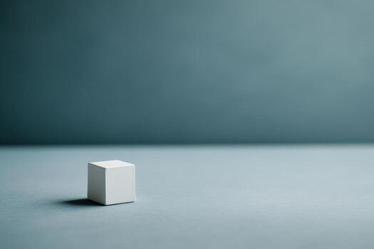 Minimalist white cube on smooth gray surface in simple composition photo