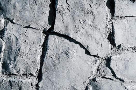 Textured concrete surface with cracks and natural patterns in sunlight photo