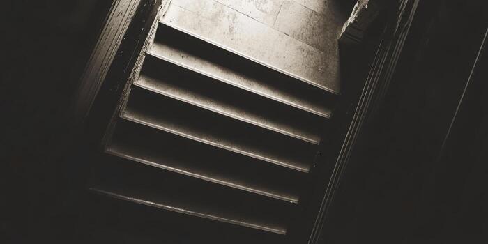 Staircase leading down with shadows creating a moody atmosphere photo