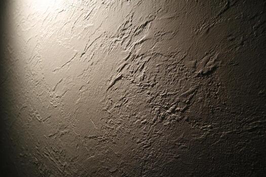 Textured concrete wall close-up with natural light and shadows photo