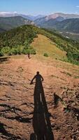 Vertical . Mountain biker navigating a scenic trail with expansive views and dynamic shadow play video