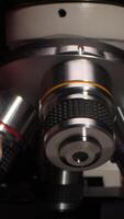 verticale scienziato mutevole obbiettivo lente di microscopio nel laboratorio video
