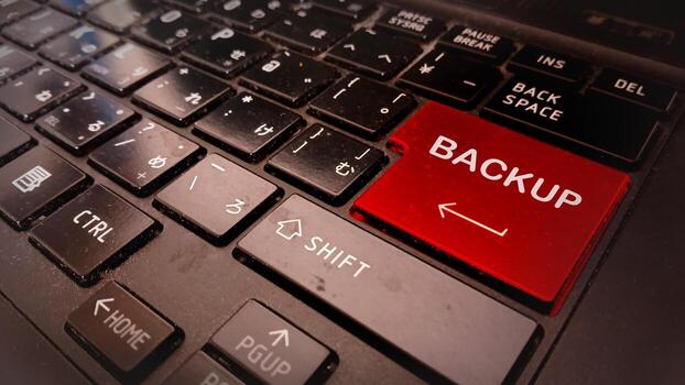 A red button on a laptop keyboard that says backup photo