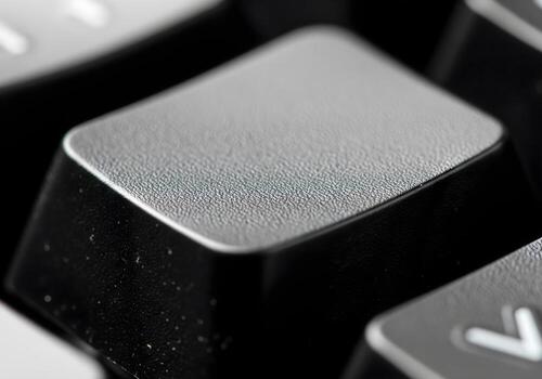 highlights a blank keycap with a slightly textured matte surface, showing fine details of its grainy finish photo