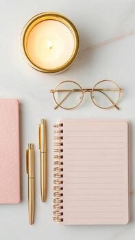 Desk arrangement with candle, glasses and notebook photo