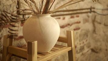 elegante cerâmico vaso com seco flores dentro rústico interior video