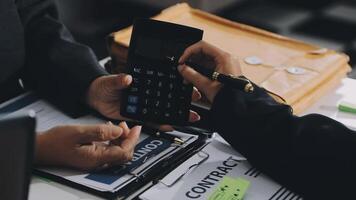 dos personas son utilizando un calculadora a calcular el costo de un contrato video