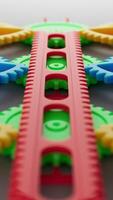 Vivid 3D loop of colorful plastic gears and racks in red, yellow, green, and blue, intermeshing and rotating in synchronized motion to create a playful, smooth, and endlessly cycling animation scene. video
