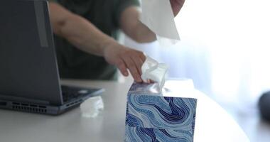 person med rinnande näsa våtservetter med servett medan arbetssätt på dator i kontor video