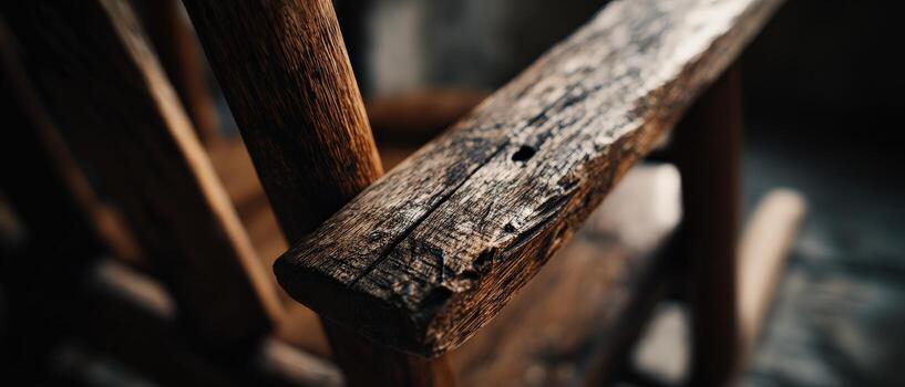 Closeup of weathered wooden rocking chair arm with visible wood grain and rustic texture, showcasing craftsmanship and vintage charm photo