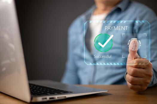 A person uses a biometric fingerprint scan for an online payment on a laptop.futuristic digital interface displays PAYMENT Successful with a green checkmark, symbol secure transactions. photo