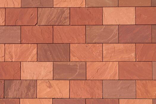 Abstract full-frame close-up of a wall of brown, terracotta-colored, and reddish rectangular bricks, showcasing their varied textures and hues in a precise, geometric pattern. photo