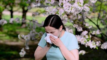 jung Frau Niesen in Gewebe im Blühen Frühling Park, Konzept von saisonal Allergie und Pollen Empfindlichkeit video