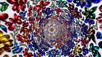 vistoso espiral de vibrante flores en un fascinante patrón, exhibiendo un continuo fluir de intrincado diseños y texturas en un cautivador movimiento secuencia video