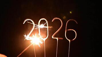Sparkler digits ignite and burn brightly to form the number 2026, glowing with festive sparks against a dark background, perfect for New Year countdown videos. video