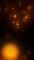 gyllene lysande partiklar spridd på en mörk bakgrund, skapande en värma abstrakt bokeh effekt video