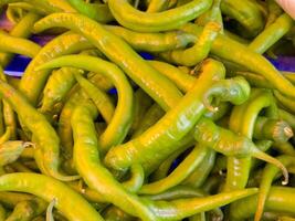 Fresco verde chile pimientos apilado juntos en un mercado de cerca foto