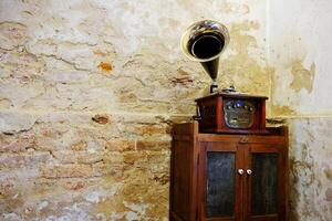 Clásico de madera gramófono música caja en antiguo de madera gabinete dentro grunge hormigón y ladrillo pared en Bangkok de tailandia Copiar espacio foto