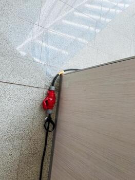 A vibrant red and black cord is securely attached to a sturdy wooden surface, ensuring reliable connections while enhancing the homes aesthetic appeal and functionality photo