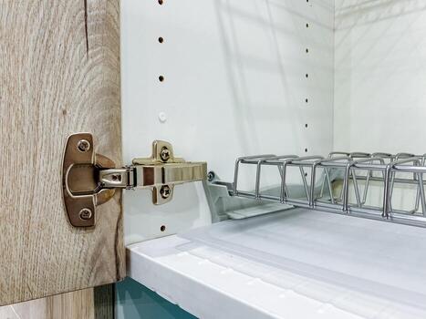 This is a detailed closeup image of a cabinet door hinge, showcasing the intricate design and functionality of the hinge on a wellcrafted cabinet used for storage or display purposes photo