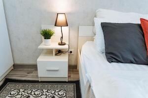 esta acogedor dormitorio tiene un felpa cama, elegante mesita de noche, calentar lámpara, y atractivo alfombra, creando un relajante atmósfera para sosegado dormir y tranquilidad, haciendo eso un Perfecto retirada foto