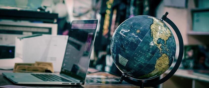 Desk Setup With Laptop and Globe in a Cozy Work Environment photo