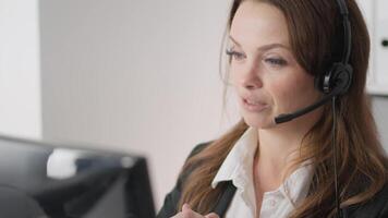 i en modern kontor, en skicklig kund service ombud användningar en headsetet till påverka varandra med kunder, demonstrera professionalism och fokus till säkerställa kund tillfredsställelse i varje engagemang video