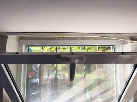 Open window in the basement, plastic window, transom in plastic windows. A window with a handle on the top photo