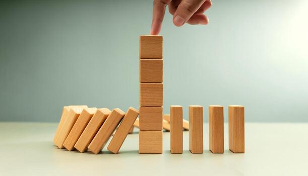 Falling row wooden blocks stopped by finger pushing one block upright. risk control, intervention, and Business strategic decision making photo