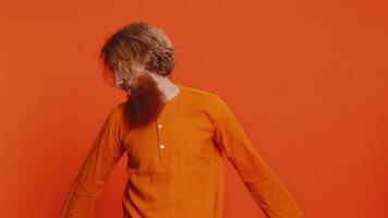 caucasian man trött uttråkad likgiltig uttryck, utmattad av tråkig berättelse, inte intresserad i kommunikation prata, missnöje, ointressant. rödhårig ung kille isolerat på studio orange bakgrund video